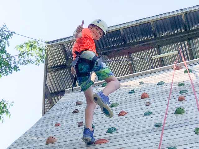 Kid repelling down rock wall