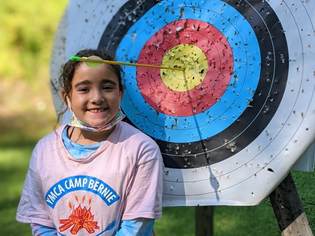Girl standing in front of archery target
