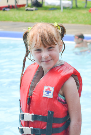 Girl in life vest at summer camp pool
